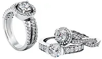 Two white gold diamond engagement ring sets shown from different angles, each featuring a round brilliant-cut center stone with a diamond halo and pavé-set split shank bands