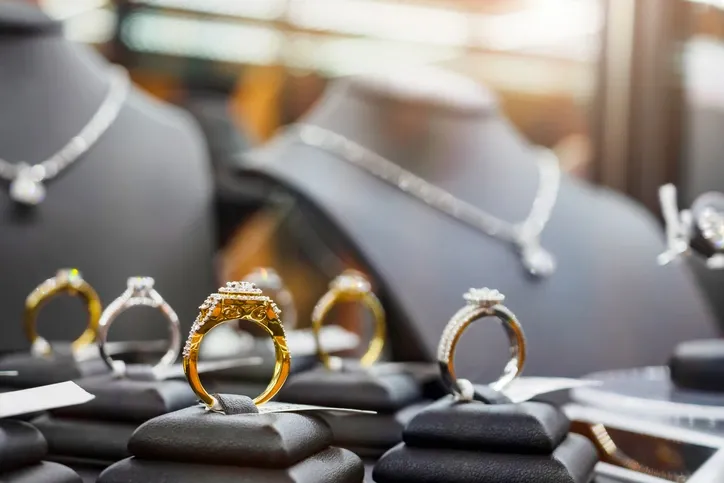 Display of rings and necklaces in a jewelry store, arranged neatly on stands.