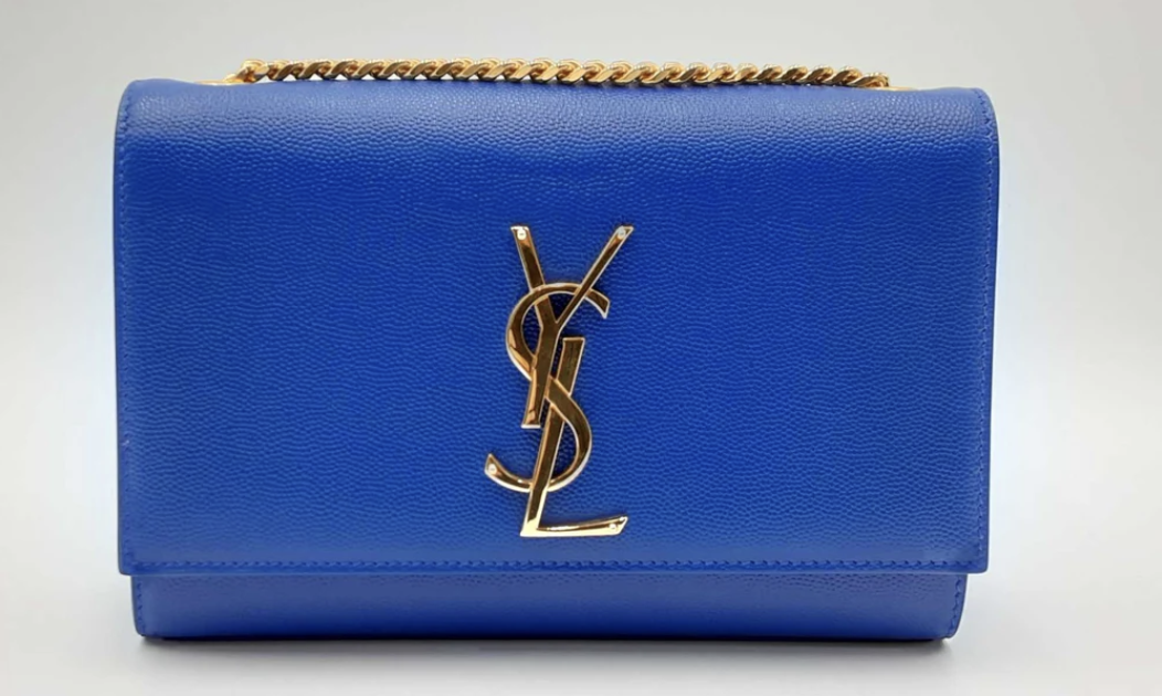 A blue Saint Laurent designer wallet with a textured exterior and a prominent gold logo, featuring a gold chain link border.